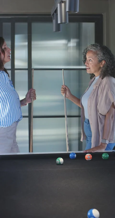 Left woman with cue gesturing, causing animated shot lines highlighting balls Stock Footage 345322580