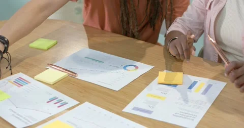 Left woman reaching at table is starting; right woman pressing notes and sorting Stock Footage 339162055
