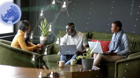 Left woman showing phone causing AR globe, cards, bits while team leaning typing Stock Footage 333463268