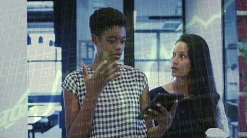Left woman tapping tablet and presenting business data to peer, overlaid charts Stock Footage 334703757