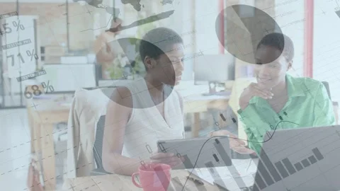 Left woman tapping tablet and showing peer confirming biz data on laptop while Stock Footage 334743662
