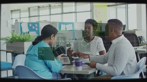 Left woman tapping tablet, HUD overlay aligning over faces, team collaborating Stock Footage 333369130