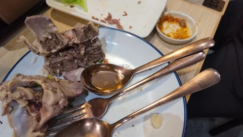 Leftover Beef Rib Bones and Dirty Cutlery on Restaurant Plate Stock Footage 343504947