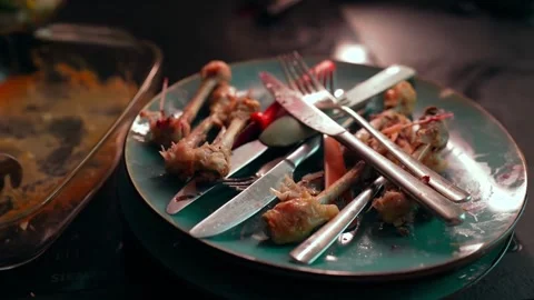 Leftover Chicken Bones and Scattered Cutlery After Dinner Stock Footage 305370255