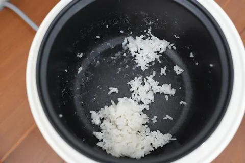 Leftover rice in the magic com. Leftover stale rice in the rice cooker. Fotos de archivo
