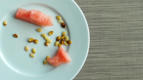 Leftovers from watermelon. View from above. On the plate revolve the remnants Stock Footage 109093299