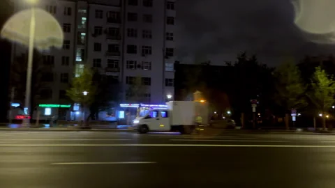 Leftside driving pov slow motion nighttime cityscape neon-lit traffic video 4k Stock Footage 302584907