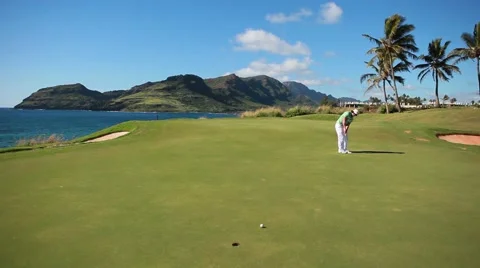 Lefty golfer making is long putt in hawaiian golf course Stock-Footage 48546756