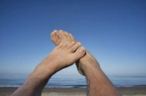 Leg and feet of a man under blue sky Stock Photos