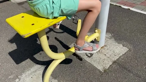 The leg breaks off. Girl performs exercises on an outdoor stationary bike Stock Footage 158832257