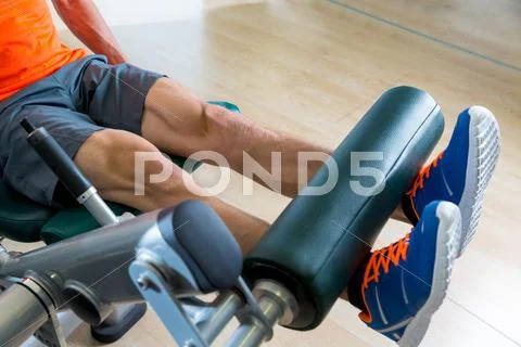 Leg extension exercise man at gym workout Stock Photos