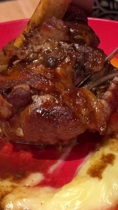 Leg of lamb with mashed potatoes cut with knife and fork restaurant food on red Stock Footage 302800991