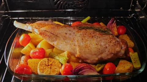 Leg of lamb with vegetables cooking process roasted in oven. Time lapse. Closeup Stock Footage 250686383