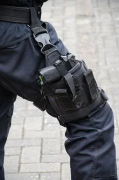 Leg of a policeman in which a firearm is found Stock Photos