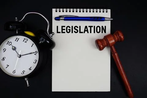 Legislation text written on notepad with gavel and alarm clock on black bac.. Stock Photos