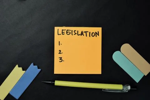 Legistation write on sticky notes isolated on office desk. Fotos de archivo