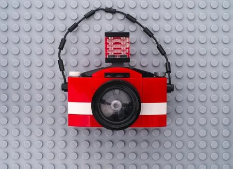 A Lego camera on a gray baseplate background. Stock Photos