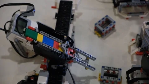 Lego robot slide and move get of particle in box Stock Footage 113084395