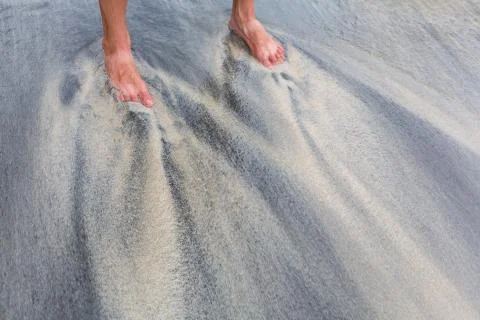 Legs and sand pattern, which creates the ocean from sand of different colors. Stock Photos