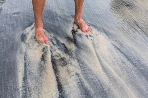 Legs and sand pattern, which creates the ocean from sand of different colors. Stock Photos