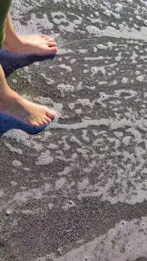 The legs are covered with sea waves. Reverse video. Great time on vacation Stock Footage 254021557