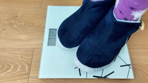 Legs Are Standing on Digital Bathroom Scale Showing Weight Reading 스톡 동영상 329904405