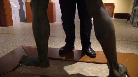 Legs of blind man close to a statue Stock Footage 140991072