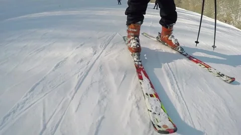 Legs in boots and ski of man riding down on slope Stock Footage 299653804