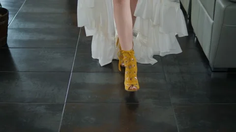 Legs of the bride in yellow shoes walking around the room. Stock Footage 131237236