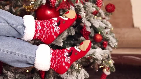 Legs in bright festive socks on the background of the Christmas tree Stock Footage 292790324