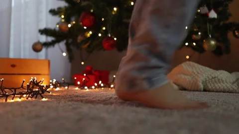 Legs close-up against the background of the Christmas tree go out of the frame Stock Footage 226830990