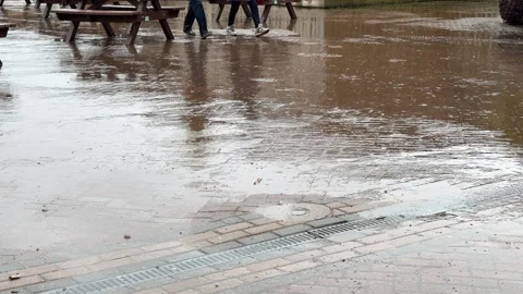 Legs of a couple walking block paving in rain background. Stock Footage 336979460