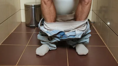 Legs dance with joy after successfully finishing in the toilet, expressing Stock Footage 303061542