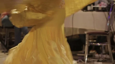 Legs of a dancing woman in a golden dress Stock Footage