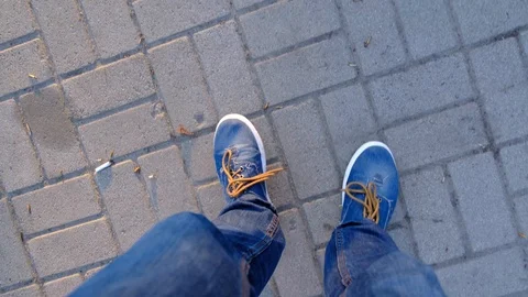 The legs of a drunken man walking down the sidewalk 動画素材 106719982