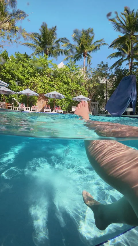 Legs Floating in Turquoise Resort Pool at Parrot Key Hotel and Villas Key West. Video stock 340542548