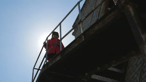 Legs go down the abandoned iron stairs of a brick building. Stock Footage 106653949
