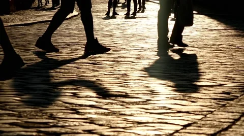 Legs of group of silhouette crowd of people walking in street with sunlight Stock Footage