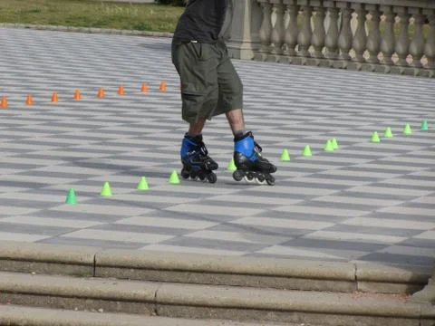 Legs of guy on inline skates . Inline skater and slalom cones Stock Photos
