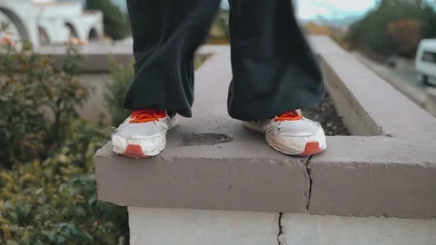 Legs of a guy standing on the wall are blowing a strong wind, the guy is Video stock 120240523
