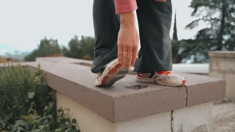Legs of a guy standing on the wall are blowing a strong wind, the guy is Stock Footage 120240559