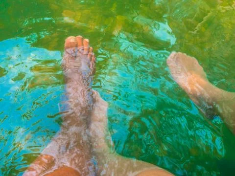 Legs in hot spring pool Stock Photos
