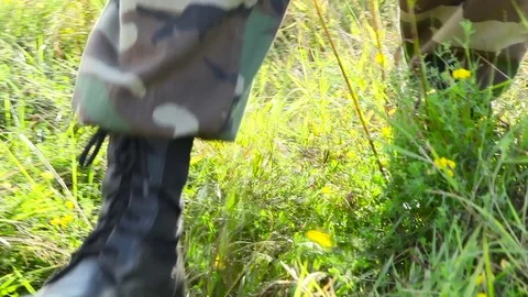 Legs of the hunter walking on the grass Stock Footage 80302687