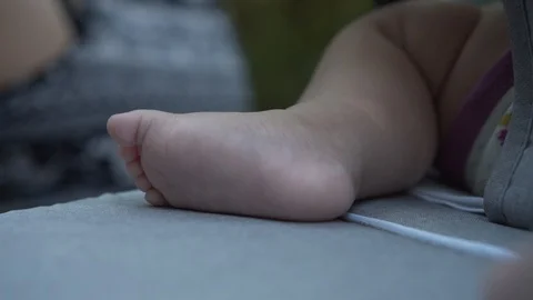Legs of infant baby in stroller. Tiny legs on newborn child in carriage outdoors Video stock 114499215