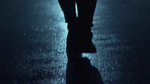 Legs of a man in backlight walking down the street at night. Stock Footage 199643633