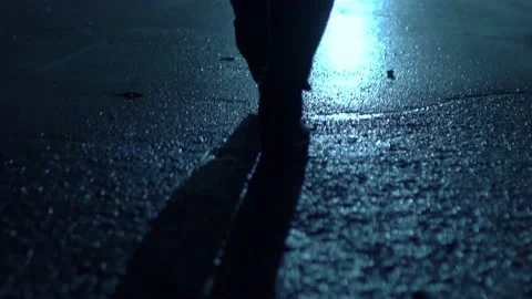 Legs of a man in backlight walking down the street at night. Stock Footage 202353344