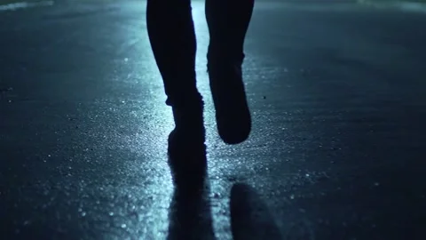 Legs of a man in backlight walking down the street at night. Stock Footage 202353789