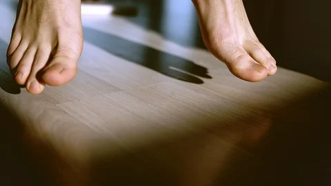 Legs of a man on a light floor jumping barefoot Stock Footage 130025056