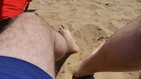 Legs of a man lying on the beach. Young man relaxing in the chaise lounge on a Stock Footage 90314054