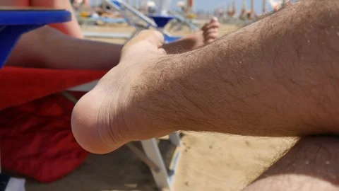 Legs of a man lying on the beach. Young man relaxing in the chaise lounge on a Stock Footage 90316179